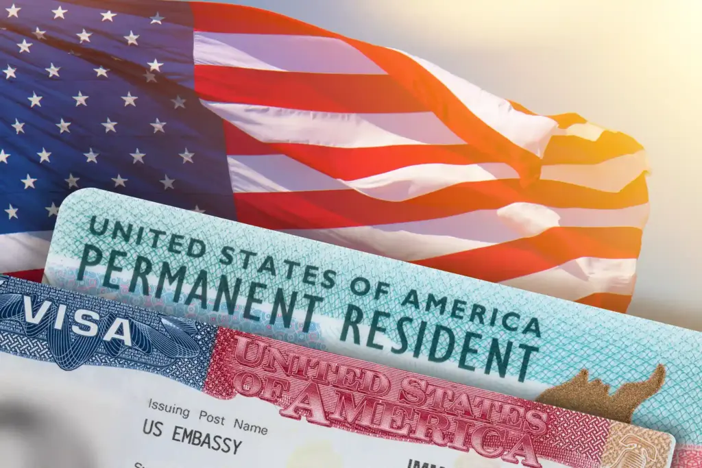 A United States Visa and green card in front of the American flag.